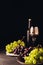 red and white grapes on vintage plates and glass with bottle of wine on wooden table