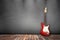 Red and white guitar on gray wall