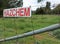 Red and white hazchem warning sign on a wire fence