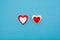 Red and white hearts on a pastel blue background. Minimal creative concept. A symbol of motherly love. Valentine`s Day