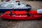 Red and white kayaks on the sand. Boats for leisure sailing laying on the beach. Kayak adventure trip. Extreme sports. Relaxing ti