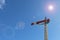 Red and white lamplight semaphore signal in blue sky with lens f