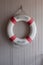 Red-white lifebuoy, safety torus on wooden board
