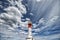 Red and white lighthouse and clouds.