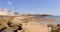 The red and white lighthouse of Rota. In the foreground the beach.