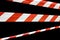 Red and white lines of barrier tape prohibit passage, tape on black isolate background