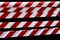 Red and white lines of barrier tape prohibit passage, tape on black isolate background