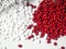 Red and white masterbatch granules on white background