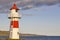 Red and white picturesque lighthouse. Faroe islands, Torshavn harbor