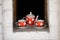 Red white polka dot teapot, cups and saucers. An old tea set stands in the window opening