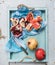 Red and white pomegranates with knife on kitchen towel in blue tray over light painted wooden backdrop