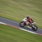 A red/white racing bike speeding round corners