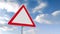 Red and white road sign over cloudy sky