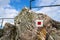 Red and white square hiking marker trail on rock