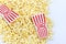 Red and white striped popcorn box with fluffy popcorn.