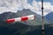 Red and white striped windsock dramatic clouds mountains in background