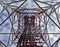 Red white telecommunication tower against blue sky and white cloud- bottom view