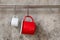 Red and white tin cup hanging on stainless rail on cement wall background