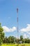 Red and white tower of communications with a lot of different antennas under clear sky.