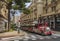 Red and white trackless tourist train of Monaco driving through city center streets near Casino Royal in Monte Carlo