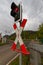 Red and white traffic sign for railroad crossing with a red stoplight