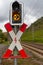 Red and white traffic sign for railroad crossing with a yellow stoplight