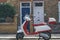 Red-white Vespa scooter parked on a street in London