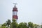 Red and white Vypin lighthouse surrounded by palm trees in Kochi, Kerala India.Puthuvype Lighthouse Bottom view.