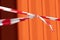 red and white warning caution tape on an orange background. Danger unsafe area warning do not enter. Concept of no entry. Copy