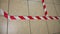 A red and white warning tape is affixed to the floor for social distancing