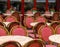 Red and white wicker chairs and small tables in outdoor cafe