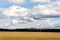 Red and white windsock on empty grassy airfield, dramatic clouds in background, windy weather forecast and air traffic