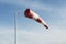Red and white windsock wind filled blue sky background