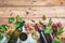 Red and white wine glasses and bottles on wooden background, copy space. Fresh grapes and grape leaves as decoration