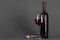 Red wine bottle  corkscrew and glass on a gray background. Wine drinking culture concept