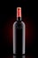 Red wine bottle with emboss at the black background with red spot