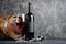 Red wine bottle with glass for tasting and wooden barrel in dark cellar