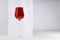 Red wine in elegant glass in sunlight with shadow in soft light white abstract minimal interior with rectangle space.