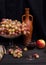 Red wine in a glass with grapes in a vase on a wooden table on a black cloth background with an old bottle. For wine advertising