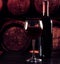 Red wine glass near bottle on wood table and in old wine cellar background