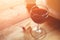 Red wine glass and old book on wooden table at sunset burst. vintage filtered image