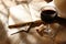 Red wine glass and old book on wooden table at sunset burst. vintage filtered image