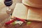 Red wine glass and old book on wooden table at sunset burst. vintage filtered image