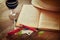 Red wine glass and old book on wooden table at sunset burst. vintage filtered image