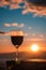 Red wine glass with the sunrise overlooking the mountains background