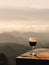 Red wine glass with sunrise overlooking the mountains Background