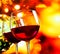 Red wine glasses against colorful unfocused lights background