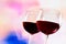 Red wine glasses against colorful unfocused lights background