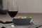 Red wine in thin wine glass with salad in blue bowl