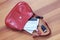 Red woman bag with protruding two sanitary masks, mobile phone, lipstick and keys.